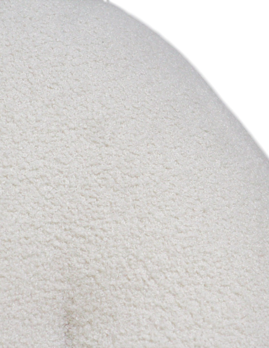 Detalle de textura bouclé en sillón blanco acabado suave