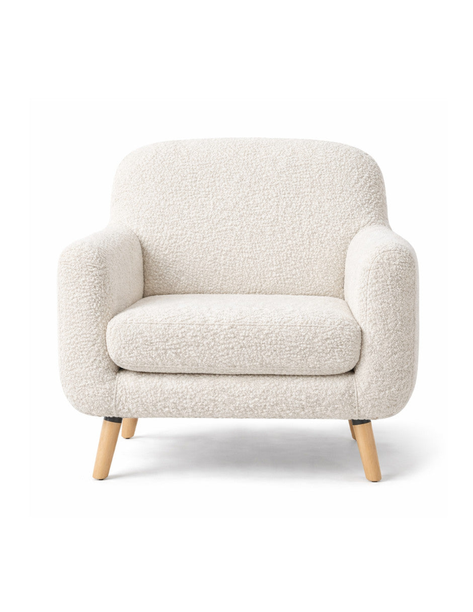 Sillón individual en tela bouclé con brazos redondeados, asiento amplio y patas de madera
