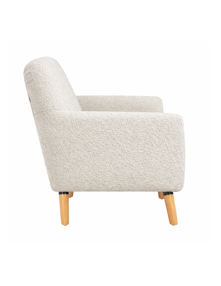 Vista lateral de sillón individual tapizado en tela boucle color blanco y  patas de madera 