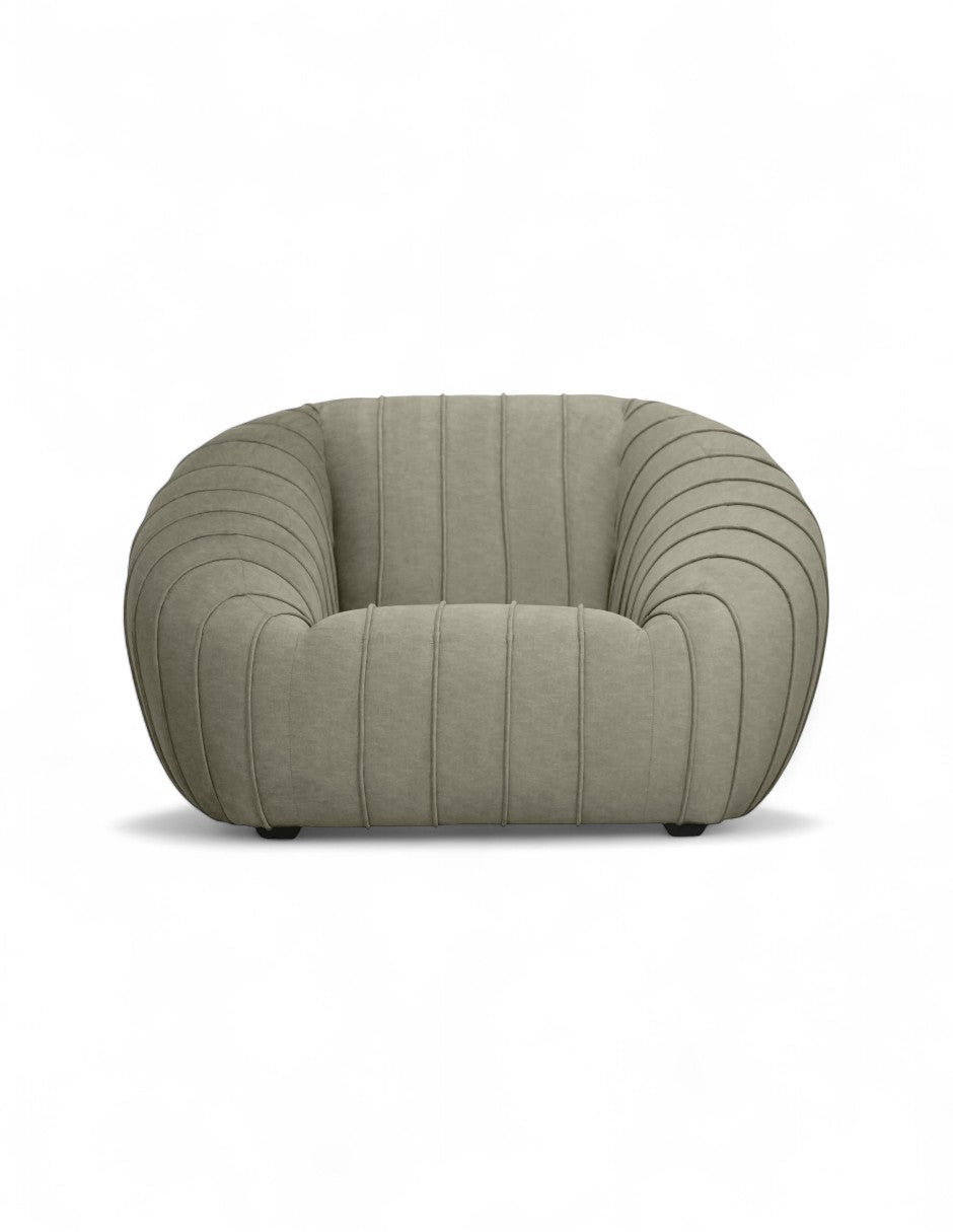 sillón moderno beige con diseño curvo y costuras verticales