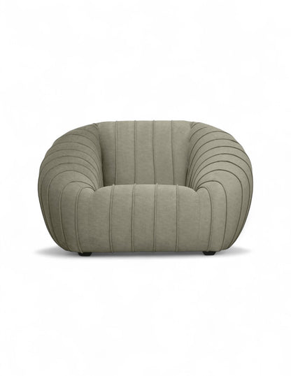 sillón moderno beige con diseño curvo y costuras verticales