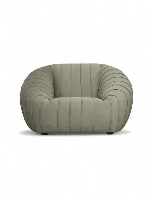 sillón moderno beige con diseño curvo y costuras verticales