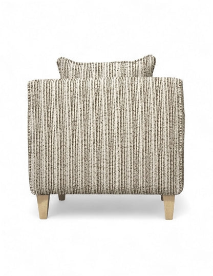Vista trasera sillón beige de tela texturizada con diseño moderno, cojín de respaldo suelto, cojín decorativo rectangular y patas de madera natural