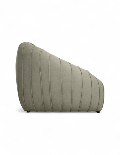 Vista lateral sillón moderno de acento beige con diseño orgánico, asiento profundo y costuras verticales