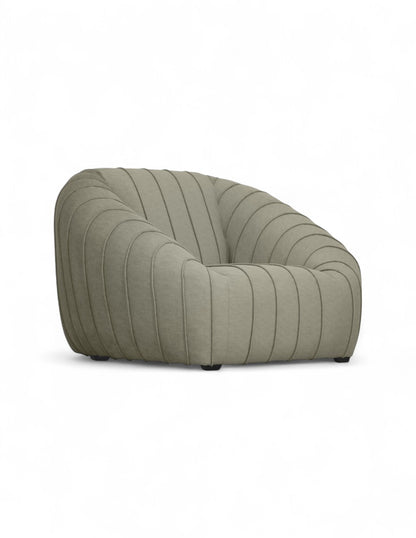 Vista 3/4 sillón moderno de acento beige con diseño orgánico,siento profundo y costuras verticales