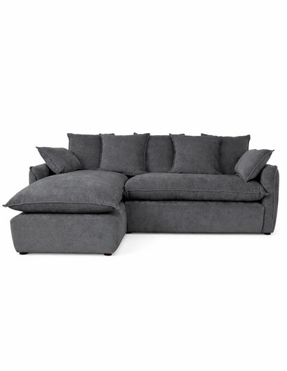 Vista frontal sofá en L gris oscuro moderno con chaise izquierdo , cojines amplios tipo almohadón 