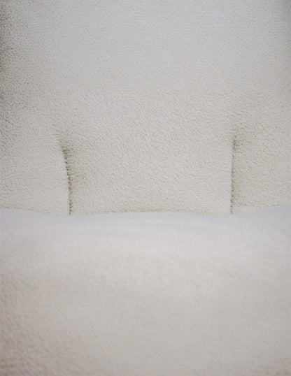Detalle de respaldo acolchado en sillón blanco tela bouclé
